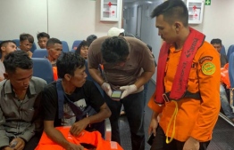 This handout photo from Search and Rescue (SAR) team and taken on March 19, 2022 and released on March 20, 2022 shows members of Search and Rescue identifying survivors during a rescue operation at sea in North Sumatra water where two people died and 26 others are missing after a ferry carrying dozens of migrants sank off the coast of Indonesia. -- Photo: . Handout / Search and Rescue / AFP
