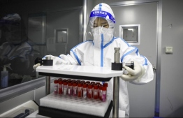 This photo taken on March 20, 2022 shows a laboratory technician clad in personal protective equipment (PPE) working at a Covid-19 testing facility in Huaian in China's eastern Jiangsu province. -- Photo: AFP