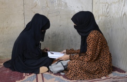 In this photograph taken on March 20, 2022, school girl Marwa Ayoubi (R) and Madina Mohammadi study at a home in Kandahar. - The reopening of secondary schools for girls across Afghanistan on March 23 has triggered joy and apprehension for tens of thousands of students deprived of education since the Taliban's return to power. -- Photo: Javed Tanveer / AFP