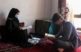 In this photograph taken on March 19, 2022, school girl Raihana (L) studies next to her brother Abdul at a home in Kunduz province. - The reopening of secondary schools for girls across Afghanistan on March 23 has triggered joy and apprehension for tens of thousands of students deprived of education since the Taliban's return to power. -- Photo: AFP