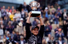 (FILES) This file photo taken on June 8, 2019 shows Australia's Ashleigh Barty posing with the trophy after winning the women's singles final match against the Czech Republic's Marketa Vondrousova on day 14 of the Roland Garros 2019 French Open tennis tournament in Paris. - Three-time Grand Slam winner and world number one Ashleigh Barty stunned the tennis world on March 23, 2022 by announcing her early retirement from the sport at the age of just 25. -- Photo: Kenzo Tribouillard / AFP