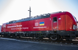An engine bringing aid supplies to the Ukraine departs from the BEHALA container terminal in Berlin on March 24, 2022; Inscription reads: "Rail bridge for the Ukraine". - German rail operator Deutsche Bahn launched a cargo train operation to deliver essential goods to war-wracked Ukraine. The company called the scheme a Schienenbruecke, German for "rail bridge" in a reference to the 1948-49 Allied "Luftbruecke" or airlift to supply West Berlin during the Soviet blockade. (Photo by John MacDougall / AFP)
