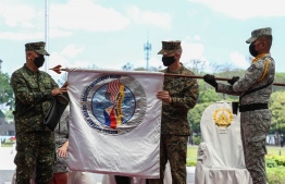 Philippine Balikatan Exercise Director Maj. Gen. Charlton Sean Gaerlan (L) and US Exercise Director Maj. Gen. Jay Bargeron (2nd R) unfurl the Balikatan flag during the opening ceremony for a 12-day joint military drill, at Camp Aguinaldo in Quezon City, east of Manila on March 28, 2022. -- Photo: Jam Sta Rosa | AFP