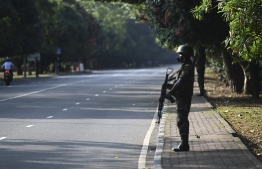 Army Soldier stand guard at a checkpoint after authorities imposed a weekend nationwide curfew to contain protests over a worsening economic crisis, in Colombo on April 3, 2022. (Photo by Ishara S. KODIKARA / AFP)