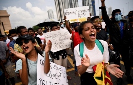 Protesters take part in a demonstration against the economic crisis at the entrance of the president's office in Colombo on April 12, 2022. - Sri Lanka announced a default on its $51 billion foreign debt on April 12 as the island nation grapples with its worst economic crisis in memory and escalating protests demanding the government's resignation. -- Photo: Ishara S. Kodikara / AFP