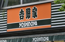 The logo of Yoshinoya, which operates a chain of popular beef bowl restaurants in Japan and abroad, is displayed at one of its eateries in Tokyo on April 19, 2022. - One of Japan's most popular fast food firms said April 19 it had fired a top executive who reportedly suggested a marketing strategy of getting "virgins addicted" to the company's products. -- Photo: Kazuhiro Nogi / AFP