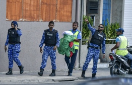Police taking away the "India Out" banners of Yameen's house on Thursday -- Photo: Fayaz Moosa /  Mihaaru