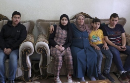 Houria Sabatien, mother of Palestinian woman Ghada Sabatien who was shot by an Israeli soldier on April 10, sits on a sofa with her grandchildren (L to R) Mustafa, Jamila, Omar, and Mohammed at their home in the village of Husan near Bethlehem in the occupied West Bank on April 18, 2022. - When Ghada Sabatien set out to visit her uncle in a village near Bethlehem, she was not expecting to be caught up in the spike in violence between Israelis and Palestinians.
But the 45-year-old, who was partially sighted and understood little Hebrew, bled to death in the street after being shot by an Israeli soldier, which the army said was a "mistake". -- Photo: Hazem Bader / AFP