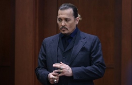 Actor Johnny Depp stands during a break in his defamation trial against his ex-wife Amber Heard, at the Fairfax County Circuit Courthouse in Fairfax, Virginia, April 21, 2022. Depp is suing ex-wife Heard for libel after she wrote an op-ed piece in The Washington Post in 2018 referring to herself as a “public figure representing domestic abuse.”  -- Photo: ” Jim Lo Scalzo/ POOL / AFP