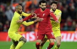Liverpool's Egyptian midfielder Mohamed Salah (C) fights for the ball with Villarreal's French midfielder Etienne Capoue (L) and Villarreal's Spanish midfielder Manuel Trigueros during the UEFA Champions League semi-final first leg football match between Liverpool and Villarreal, at the Anfield Stadium, in Liverpool, on April 27, 2022. -- Photo by Oli Scarff / AFP