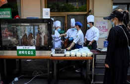 Employees prepare takeout food outside a restaurant after the government banned dining at restaurants to curb the spread of the Covid-19 coronavirus in Beijing on May 5, 2022. -- Photo: Jade Gao / AFP