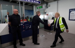 Britain's Prime Minister Boris Johnson (L) speaks with UK Border Force agents at the Southampton airport, on May 4, 2022 as part of his visit to the Eastleigh constituency ahead of the local elections. - Voters will cast ballots on May 5, 2022 across Britain for the local elections ratcheting up the pressure on Prime Minister Boris Johnson in England. -- Photo: Adrian Dennis / POOL / AFP
