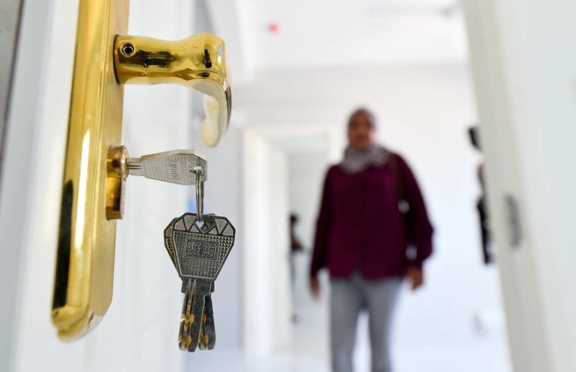 ސްޓެލްކޯގެ ފްލެޓެއްގެ ދޮރުގައި ތަޅުދަނޑި ޖަހާފައިވާއިރު، މީހަކު މަޑުކޮށްލައިގެން. މި ފްލެޓްތަކުގެ ތަޅުދަނޑި ލިބޭނެ ދުވަހެއްގެ އިންތިޒާރުގައި ތިބޭތާ ދުވަސްތަކެއް ވެއްޖެ.---ފޮޓޯ: ފަޔާޒު މޫސާ| މިހާރު