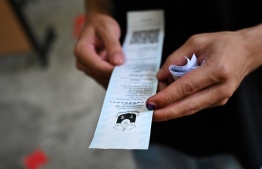 A man checks his ballot during the presidential election at a polling station in Manila on May 9, 2022. -- Photo: Chaideer Mahyuddin / AFP
