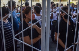 People queue up outside a polling precinct during the presidential election in Cainta, Rizal province on May 9, 2022. -- Photo: Maria Tan / AFP