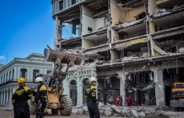 Rescue workers remove debris from the ruins of the Saratoga Hotel, in Havana, on May 8, 2022. - The death toll from an accidental explosion at a luxury hotel in central Havana rose to 30 on Sunday, authorities said, as firefighters continued to comb through the rubble. -- Photo: Adalberto Roque / AFP