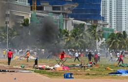 Demonstrators and government supporters clash outside the President's office in Colombo on May 9, 2022. - Police imposed an indefinite curfew in Sri Lanka's capital on May 9 after government supporters clashed with demonstrators demanding the resignation of President Gotabaya Rajapaksa. (Photo by Ishara S. KODIKARA / AFP)