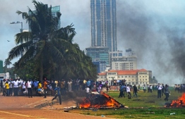 Demonstrators and government supporters clash outside the President's office in Colombo on May 9, 2022. - Police imposed an indefinite curfew in Sri Lanka's capital on May 9 after government supporters clashed with demonstrators demanding the resignation of President Gotabaya Rajapaksa. -- Photo: Ishara S. Kodikara / AFP