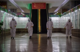 (FILES) In this file photo taken on December 28, 2020 health workers spray disinfectant inside the Pyongyang Department Store No. 1 prior to opening for business, in Pyongyang on December 28, 2020. - North Korea on May 12, 2022 confirmed its first-ever case of Covid-19, with state media declaring it a "severe national emergency incident" after more than two years of purportedly keeping the pandemic at bay. -- Photo: Kim Won Jin / AFP
