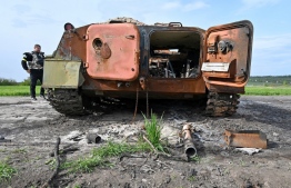  A Ukrainian serviceman looks at a destroyed armored personnel carrier (APC) near Kharkiv on May 11, 2022, amid Russian invasion of Ukraine -- Photo: Sergey Bobok / AFP