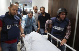 Palestinian cameraman Mujahed al-Saadi (C-L) of Palestine Today TV weeps as he escorts with other journalists the body of veteran Al-Jazeera reporter Shireen Abu Aqleh (Akleh), who was shot dead as she covered a raid on the West Bank's Jenin refugee camp, on May 11, 2022, at the hospital in Jeni --Photo by Jaafar Ashtiyeh / AFP