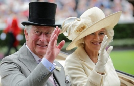 (FILES) In this file photo taken on June 19, 2018 Britain's Prince Charles, Prince of Wales (L) and his wife Britain's Camilla, Duchess of Cornwall wave as they arrive on day one of the Royal Ascot horse racing meet, in Ascot, west of London. - Prince Charles heads to Canada this week to represent head of state Queen Elizabeth II, but with more attention than ever on his future role due to his mother's age and failing health. -- Photo: Daniel Leal / AFP