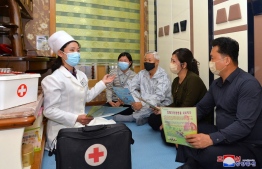 This picture taken on May 17, 2022 and released from North Korea's official Korean Central News Agency (KCNA) on May 18 shows a doctor promoting epidemic prevention measures to prevent the spread of the Covid-19 coronavirus in Pyongyang. -- Photo: KCNA VIA KNS / AFP