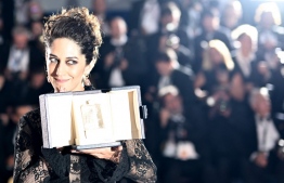 Iranian actress Zar Amir-Ebrahimi poses with her trophy during a photocall after she won the Best Actress Prize for her part in "Holy Spider" during the closing ceremony of the 75th edition of the Cannes Film Festival in Cannes, southern France, on May 28, 2022. (Photo by LOIC VENANCE / AFP)