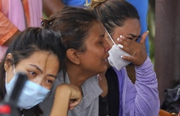 Family members and relatives of passengers on board the Twin Otter aircraft operated by Tara Air, weep outside the airport in Pokhara on May 29, 2022. - A passenger plane with 22 people on board went missing in Nepal on May 29, the operating airline and officials said, as poor weather hampered a search operation. -- Photo: Yunish Gurung / AFP
