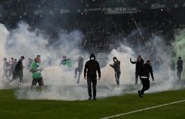 Saint-Etienne's fans invade the pitch through smoke after being defeated at the end of the French L1-L2 play-off second leg football match between AS Saint-Etienne and AJ Auxerre at the Geoffroy Guichard Stadium in Saint-Etienne, central-eastern France on May 29, 2022. -- Photo: Jean-Philippe Ksiazek / AFP