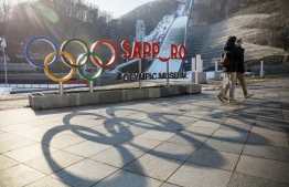 This picture taken on November 30, 2021 shows Olympic signage in front of the Sapporo Olympic Museum near the Okurayama ski jumping platform in Sapporo, Hokkaido prefecture. - International Olympic Committee officials on May 31 began inspecting competition venues in the northern Japanese city of Sapporo, seen as a frontrunner to host the 2030 Winter Games. -- Photo: Jiji Press / AFP