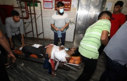 Rescue workers and civilians carry an injured victim to a hospital in Chittagong, after a fire broke out at a container storage facility in Chittagong, on June 5, 2022. - At least five people died and some 100 were injured after a massive fire tore through a container depot in Bangladesh's southeastern town of Sitakunda, officials said on June 5, 2022. -- Photo:  AFP