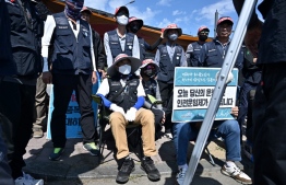 South Korean truck drivers who are on strike have a meeting outside a container port in Incheon on June 14, 2022, on the eighth day of protests over rising fuel costs that have further snarled global supply chains. -- Photo: Anthony Wallace / AFP