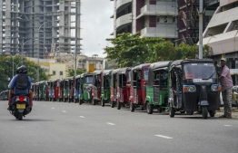 Autorickshaw drivers queue along a street to buy petrol from a Ceylon petroleum corporation fuel station in Colombo on June 17,2022. -- Photo: AFP
