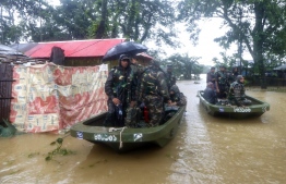 Bangladesh army personnel evacuate affected people from a flooded area following heavy monsoon rainfalls in Sylhet on June 18, 2022. - Monsoon storms in Bangladesh have killed at least 25 people and unleashed devastating floods that left more than four million others stranded, officials said Saturday. (Photo by MD Abu Sufian Jewel / AFP)