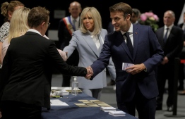 French President Emmanuel Macron and his wife Brigitte Macron arrive to vote in the second stage of French parliamentary elections at a polling station in Le Touquet, northern France on June 19, 2022. -- Photo: Michel Spingler / POOL / AFP