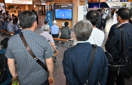 People watch a television screen showing a live footage of South Korea's homegrown space rocket Nuri, at a railway station in Seoul on June 21, 2022, as the 200-ton Nuri blasted off from the Naro Space Center on the south coast in the second attempt to put satellites into orbit after a launch last October failed. -- Photo: Jung Yeon-je / AFP