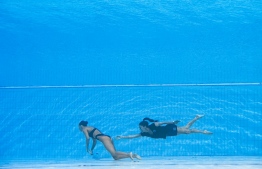 A member of Team USA (R) recovers USA's Anita Alvarez (L), from the bottom of the pool during an incendent in the women's solo free artistic swimming finals, during the Budapest 2022 World Aquatics Championships at the Alfred Hajos Swimming Complex in Budapest on June 22, 2022. -- Photo:  Oli Scarff / AFP