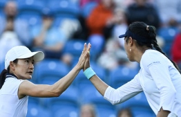 Japan's Shuko Aoyama (L) and Taiwan's Chan Hao-ching (R) react as they play against Serena Williams of the US and Tunisia's Ons Jabeur during their women's doubles quarter final tennis match on day four of the Eastbourne International tennis tournament in Eastbourne, southern England on June 22, 2022. -- Photo: Glyn Kirk / AFP
