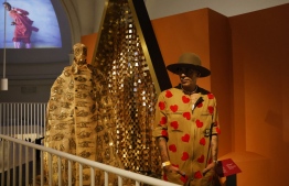 Moroccan fashion designer Artsi Ifrach poses for a photograph next to his creation "A Dialogue Between Cultures" during a photo call for the 'Africa Fashion' exhibition at the Victoria and Albert museum in London on June, 27, 2022. --  Photo: Carlos Jasso / AFP
