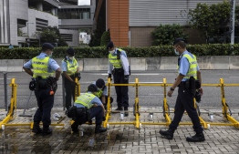 Police set up road blocking equipment near West Kowloon Station in Hong Kong on June 30, 2022, ahead of Chinese President Xi Jinping's arrival in Hong Kong to celebrate the 25th anniversary of the handover of Hong Kong from Britain to China taking place on July 1. -- Photo: Isaac Lawrence / AFP