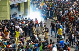 Police fire tear gas canisters to disperse protesters demanding the resignation of Sri Lanka's President Gotabaya in a street leading to Sri Lanka's Presidential Palace in Colombo on July 9, 2022. - Sri Lanka's beleaguered President Gotabaya Rajapaksa fled his official residence in Colombo, a top defence source told AFP, before protesters gathered to demand his resignation stormed the compound. (Photo by AFP)