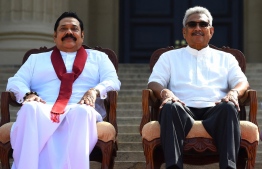 (FILES) In this file photo taken on November 22, 2019, Sri Lanka's new President Gotabaya Rajapaksa (R) and his Prime Minister brother Mahinda Rajapaksa, pose for a group photograph after the ministerial swearing-in ceremony in Colombo. - Millions of rupees in cash left behind by President Gotabaya Rajapaksa when he fled his official residence in the capital will be handed over to court on July 11, 2022, police said. (Photo by ISHARA S. KODIKARA / AFP)