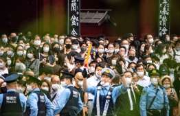 People gather for the hearse carrying late former Japanese prime minister Shinzo Abe to leave Zojoji Temple in Tokyo on July 12, 2022. -- Photo: Philip Fong / AFP