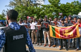 Protesters hold Sri Lankan flag, along with posters during the protest in Male', over Maldives providing protection for Sri Lankan President Gotobaya Rajapakse, on Wednesday, July 13, 2022 -- Photo: Nishan Ali/ Mihaaru