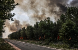 This picture taken on July 17, 2022, shows a forest fire near Louchats in Gironde, southwestern France. - The intense mobilisation of firefighters did not weaken on July 17, 2022 to fix the fires in the south of France, and particularly in Gironde where new evacuations are in progress in front of the advance of the flames which ravaged more than 10.000 hectares of forests since it is started on July 12, in a context of generalised heat wave all weekend. -- Photo: Thibaud Moritz / AFP