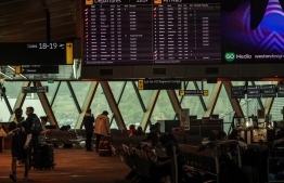 A flight information board shows cancelled flights at the airport in Wellington on July 21, 2022. - High winds and multi-storey waves battered New Zealand's east coast on July 21, forcing airports and seaports to halt operations and ripping the roof off at least one building. -- Photo: Dave Lintott / AFP