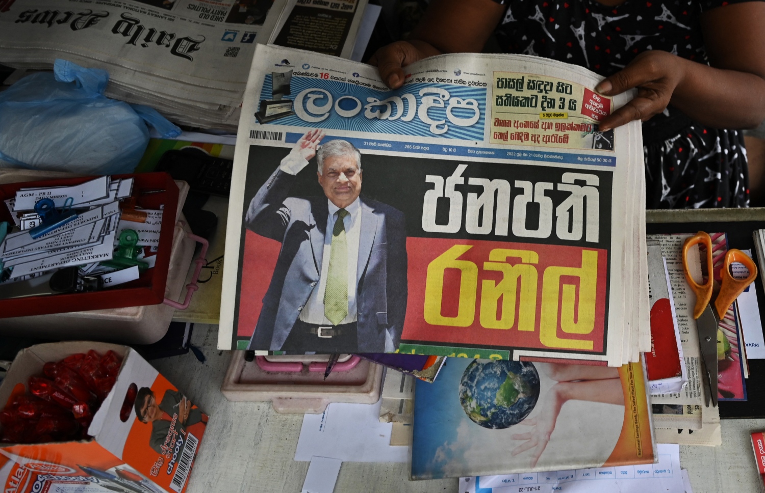 ޖުލައި 21، 2022: ލަންކާގެ ގާނޫނު ހަދާ މަޖިލީހުގައި އިއްޔެ ނެގި ވޯޓުގައި އެ ގައުމުގެ ރައީސްކަމުގެ މަގާމަށް އިންތިޚާބުކުރި ރަނިލް ވިކްރަމަސިންހަ، ގައުމުގެ ވެރިކަމާ ހަވާލުވި ޚަބަރު ލަންކަގެ ނޫސްތަކުގައި ޝާއިއުކޮށްފައި. --އޭއެފްޕީ