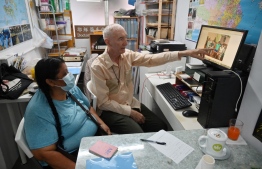 This photo taken on May 9, 2022 shows Peruvian national Zoila Lecarnaque Saavedra (L), recently released after serving time in prison for drug trafficking and now awaiting deportation, talking to Father John Wotherspoon, a Catholic prison chaplain who has spent decades working with drug mules, in his office in the Jordan area of Hong Kong. - Zoila Lecarnaque Saavedra sealed her fate when she agreed to transport a package from Peru to Hong Kong -- a decision that landed her more than eight years in prison. A quarter of Hong Kong's prisoners are women, a record-high percentage skewed by impoverished foreign drug mules who are often duped or coerced. -- Photo: Peter Parks / AFP
