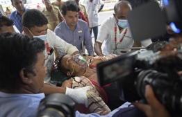 A man is shifted on a stretcher upon arriving in an ambulance at the civil hospital in Ahmedabad on July 26, 2022, after suffering health problems due to consuming bootleg liquor. -- Photo: Sam Panthaky / AFP